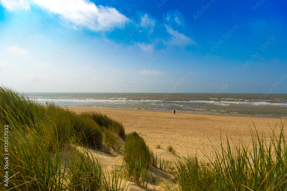 People walking in distance at the Belgian north sea coast near De Haan, Belgium
