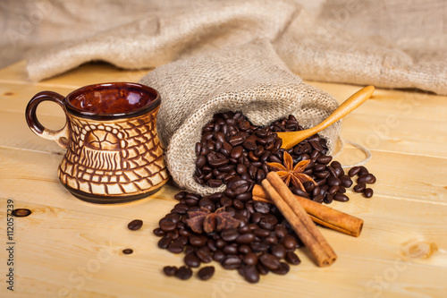 cup of coffee and coffee beans on a wooden surface