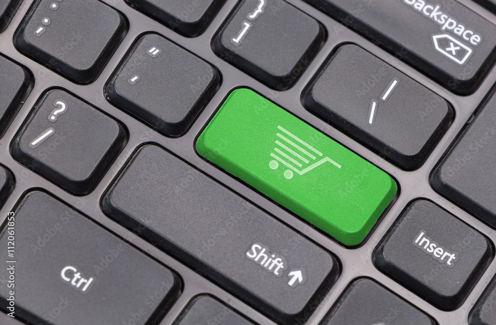 Computer keyboard closeup with shopping cart icon on green enter key Computer keyboard closeup with shopping cart icon on green enter key