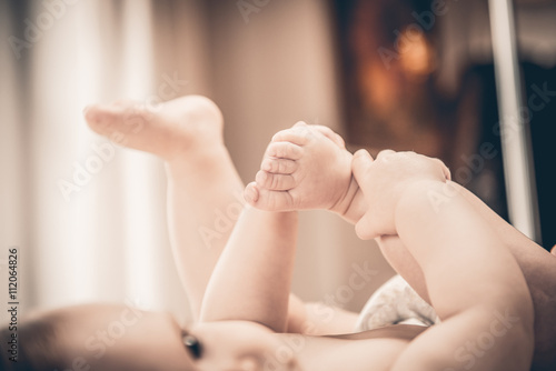 Baby holds his small hands their feet close-up