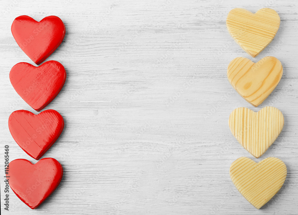 Obraz premium Red and wooden heart shapes on white wood background, love and romance concept, valentine's day celebration