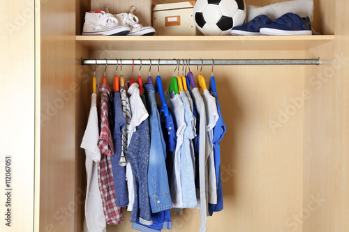 Boy clothes on hangers in the wardrobe