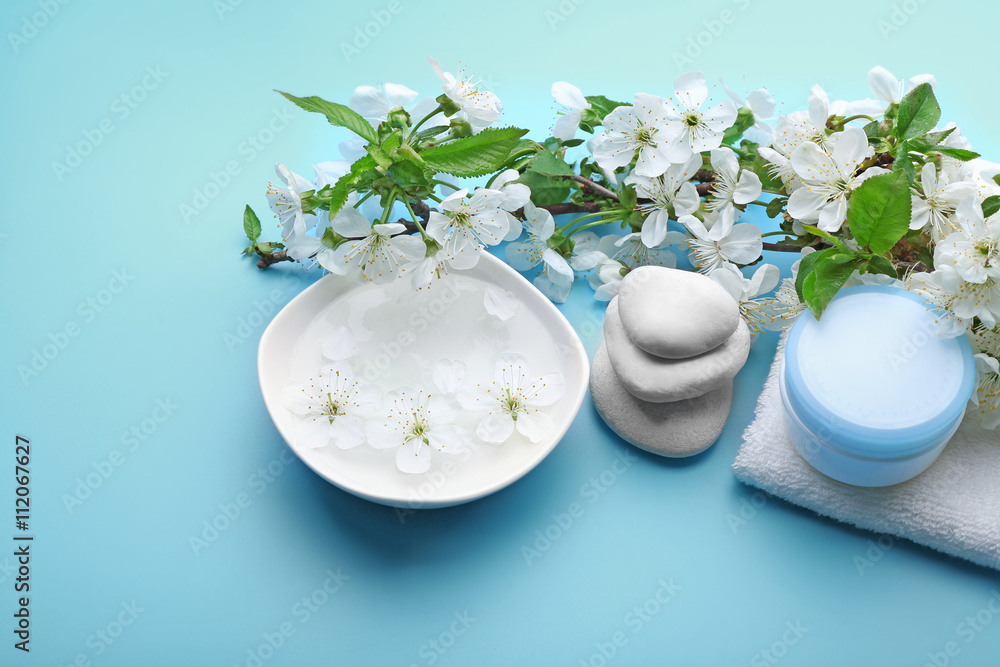 Spa treatment with blooming branch on blue background Spa treatment with blooming branch on blue background