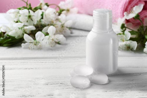 Cosmetic in bottle on white wooden table