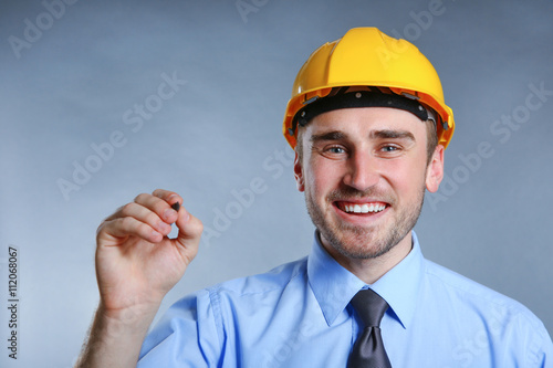 Man in helmet holding penci...
