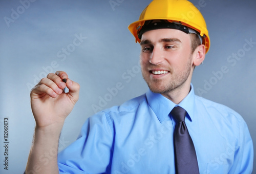 Man in helmet holding penci...