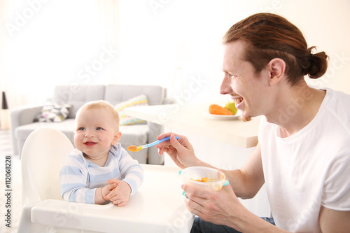 Father feeding his baby son