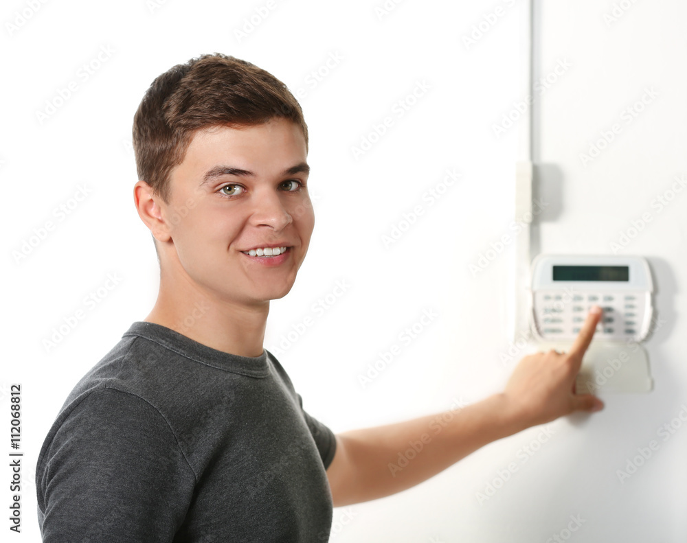 Man pressing the code on a house alarm Man pressing the code on a house alarm