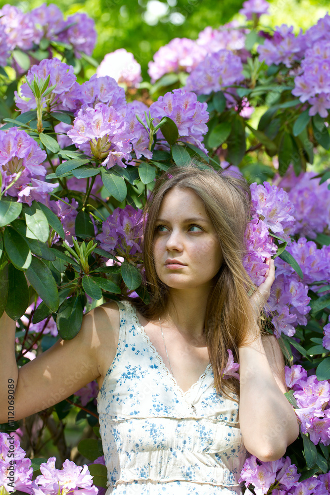 Fototapeta premium beautiful young woman and blooming rhododendron