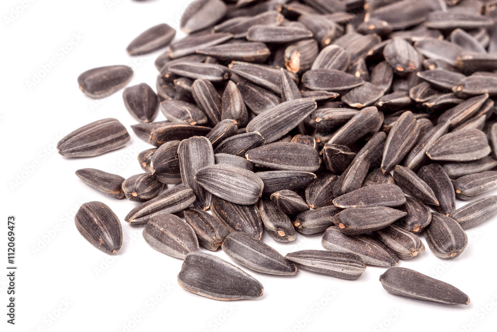 unpeeled sunflower seeds on a white background