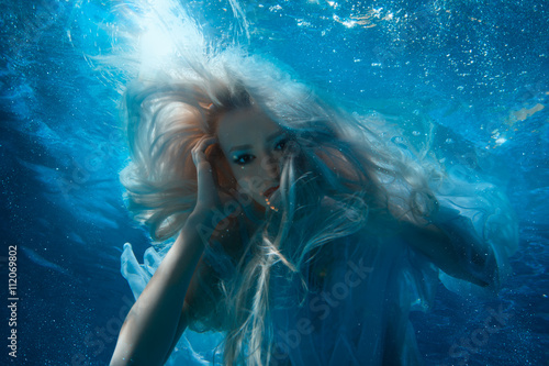 Woman with long blonde hair underwater.