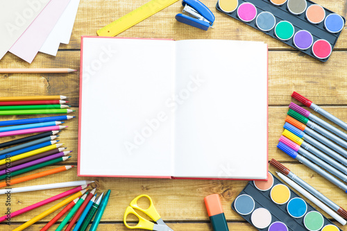 School items make a frame on wooden background
