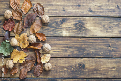 Dry autumn leaves on wooden background