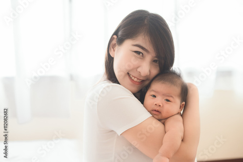 Happy mother holding adorable child baby boy