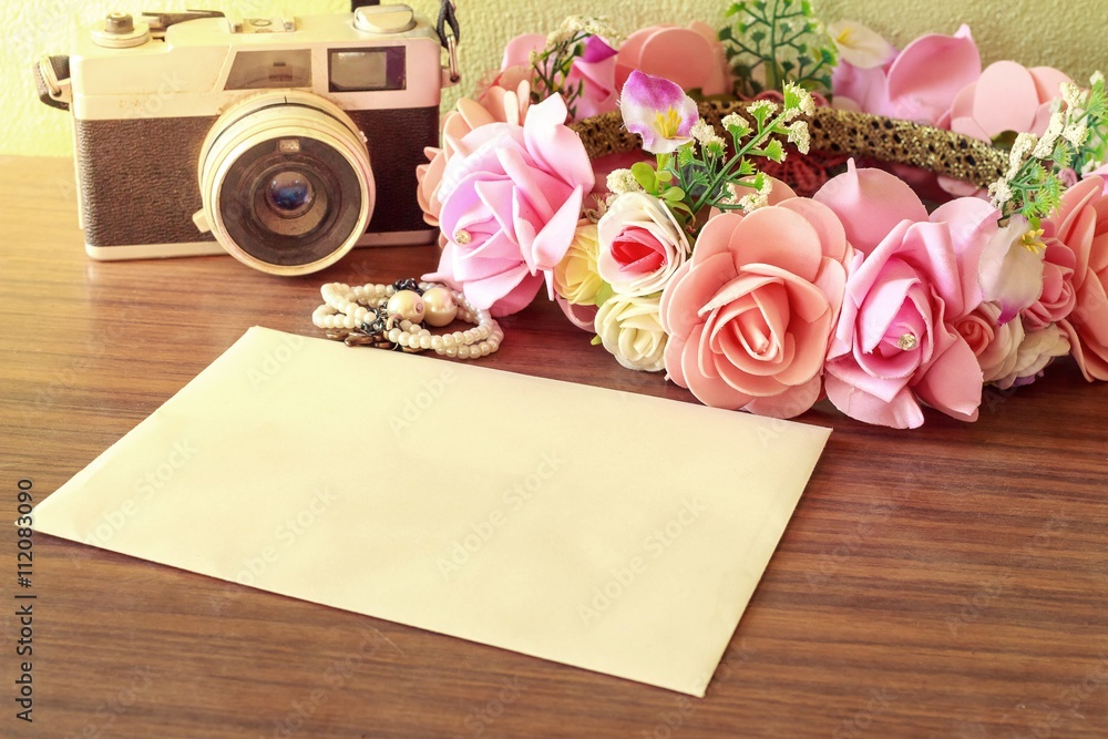 Obraz premium fresh pink and white roses and camera film with empty paper not