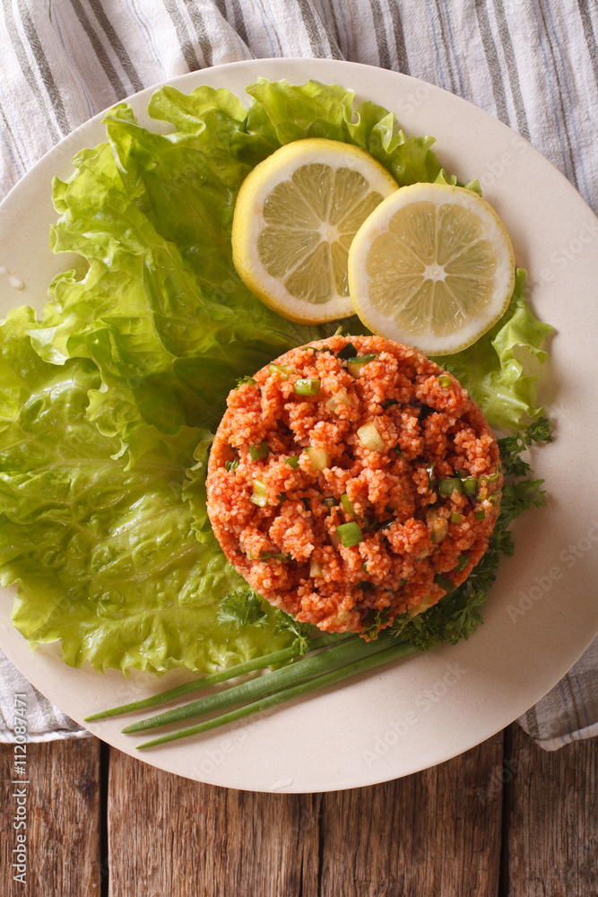 Turkish appetizer spicy kısır of bulgur with herbs on the table. Vertical top view
Turkish appetizer spicy kısır of bulgur with herbs on the table. Vertical top view