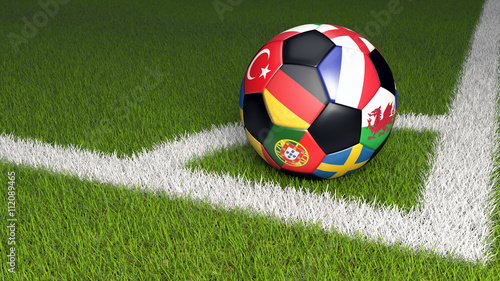 Bunter Fu  ball mit Nationalflaggen der Teams der EM 2016. Eckball auf gr  nem Rasen.