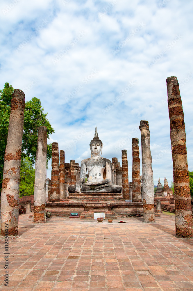 Ancient statues of buddha and palace buildings at Sukhothai Hist