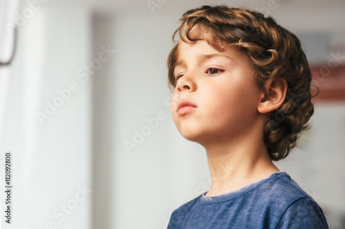 Cute little boy with curly hair looking away