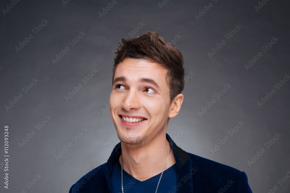portrait of a happy young man smiling on gray background portrait of a happy young man smiling on gray background