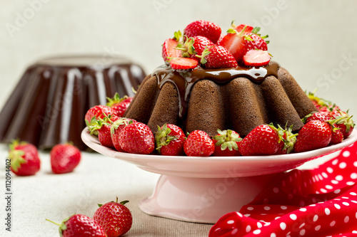 Chocolate cake. Decorating with chocolate icing and strawberries