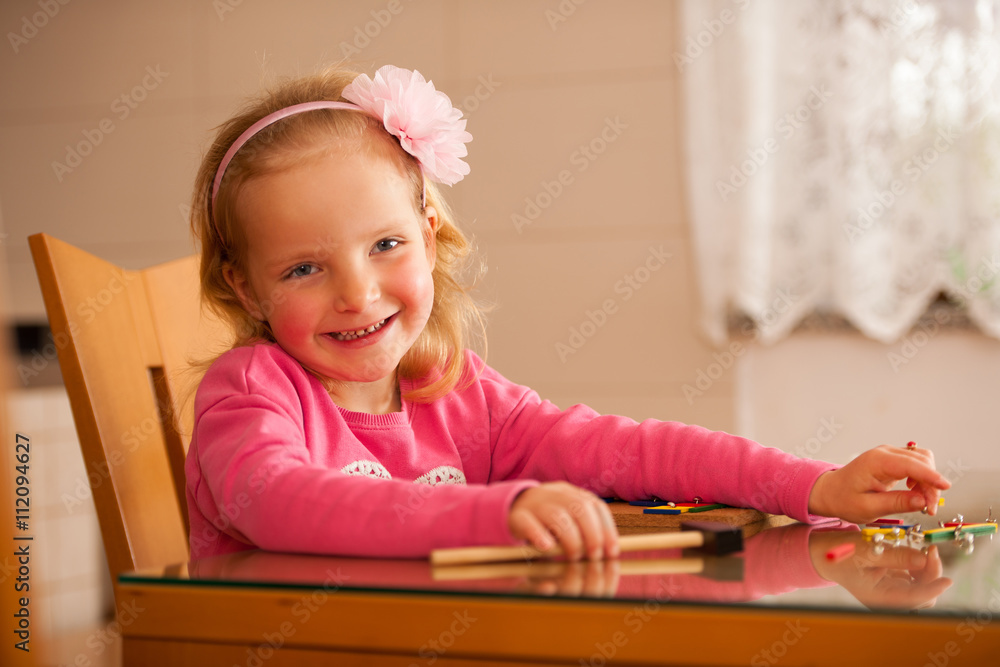 Cute little girl pin pointing blocks into wooden board playing w Cute little girl pin pointing blocks into wooden board playing w