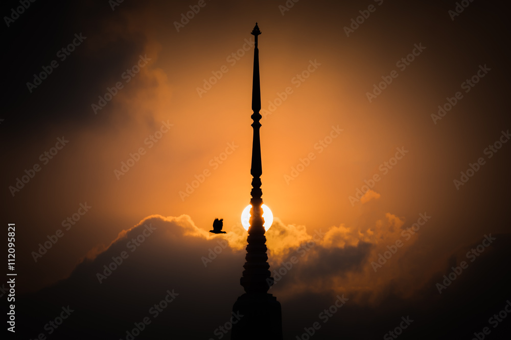 Obraz premium Bird flying with pagoda sunset background