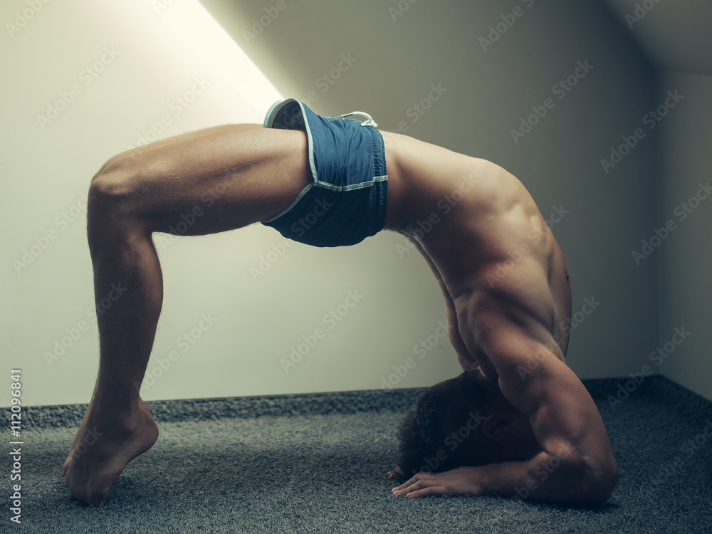 Muscular yoga man in bridge position Muscular yoga man in bridge position