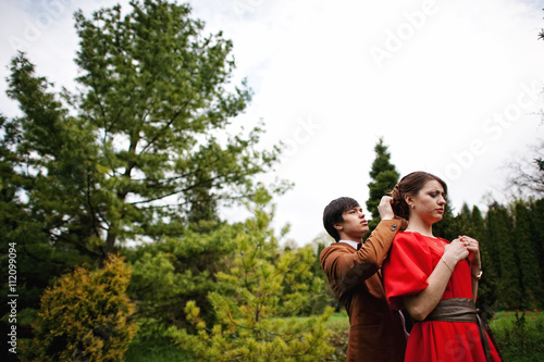 Couple hugging in love at beautiful landscape of trees and meado