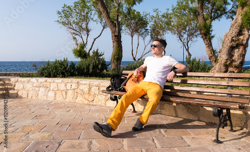 guy sitting on a bench near the sea
