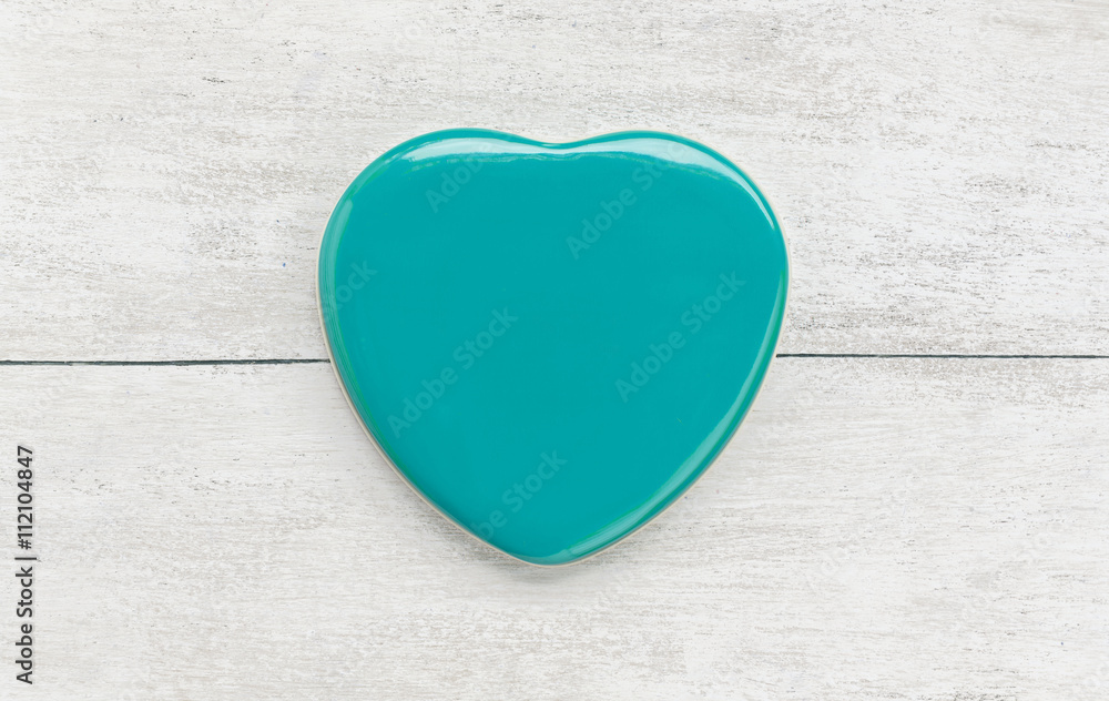Obraz premium Green heart shape on white wood background