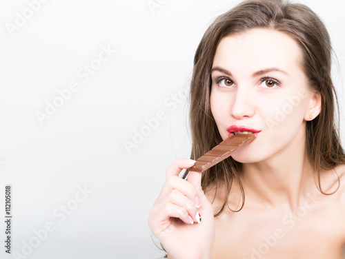 close-up portret of beautiful sexy woman with red lips eating chocolate