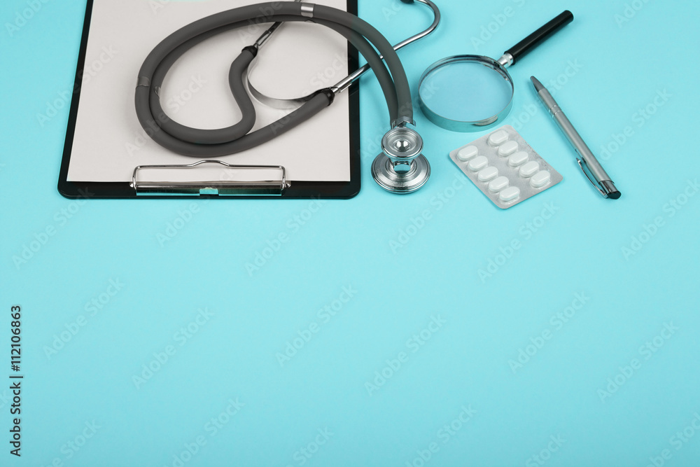 doctors workplace - medical tablet, stethoscope, pills and magnifying glass doctors workplace - medical tablet, stethoscope, pills and magnifying glass