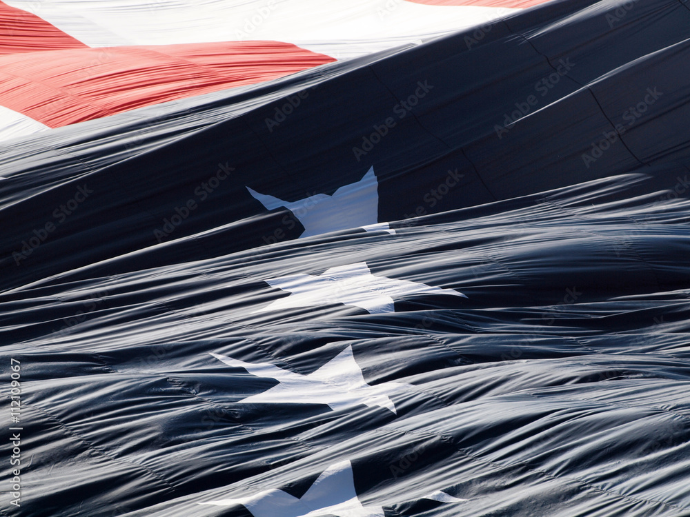 Giant USA flag unraveling puffing in the air Giant USA flag unraveling puffing in the air