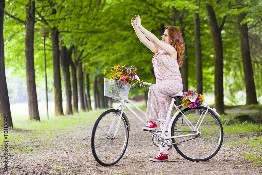 Naklejka premium Beautiful girl on bike taking a selfie