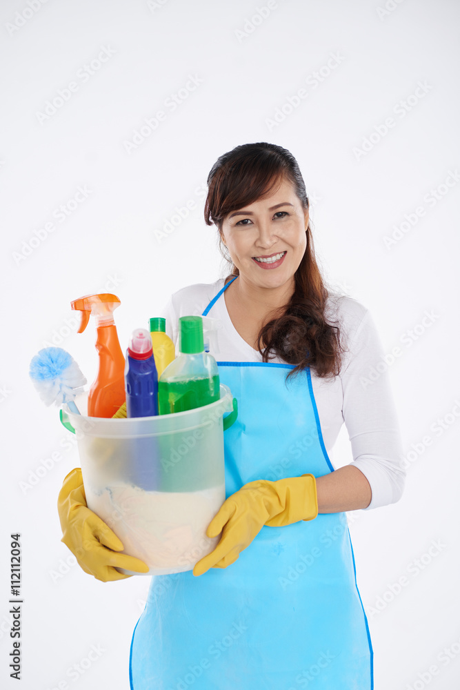 Smiling Asian housewife with basket of cleaning supplies Smiling Asian housewife with basket of cleaning supplies