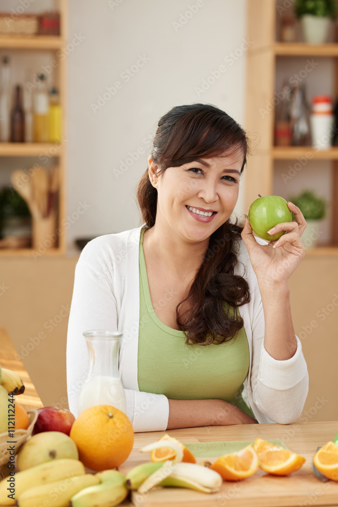 Female vegetarian with many fruits on table in front of her Female vegetarian with many fruits on table in front of her