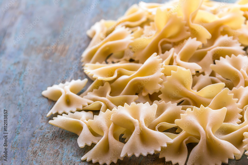 Farfalle pasta on the wooden base. Farfalle pasta on the wooden base.