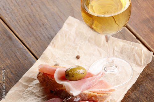 Open jamon sandwiches with white wine photo