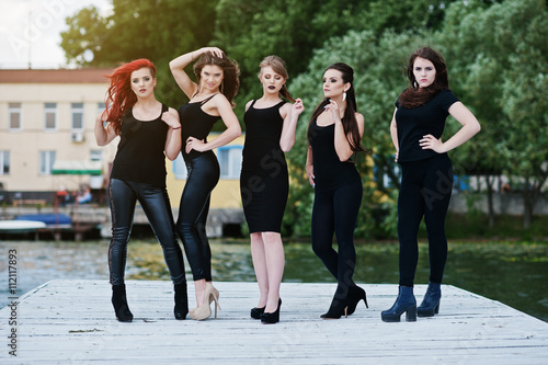 Five beautiful young sexy girls models in black tight dress posi