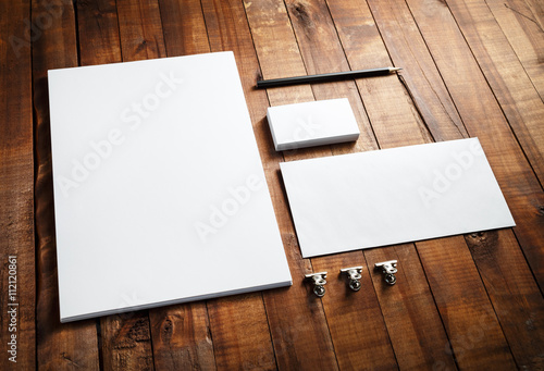 Blank stationery and corporate identity set on vintage wooden table background: letterhead, business cards, envelope and pencil. Blank mock-up for design portfolios.