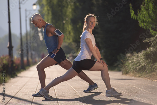 couple warming up and stretching before jogging