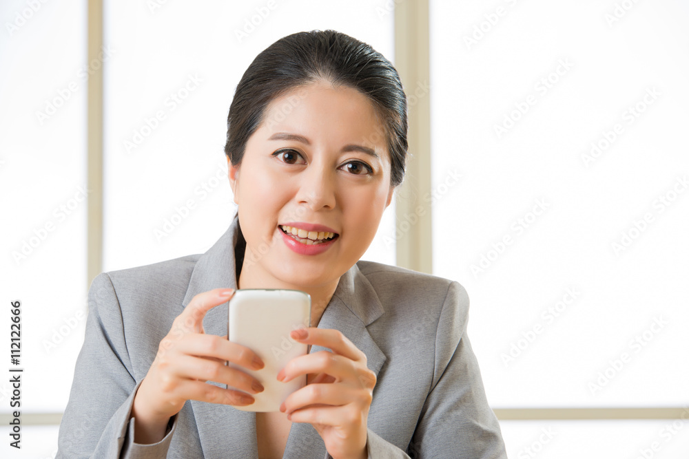 Beautiful Asian woman smiling and using smart phone text messagi Beautiful Asian woman smiling and using smart phone text messagi
