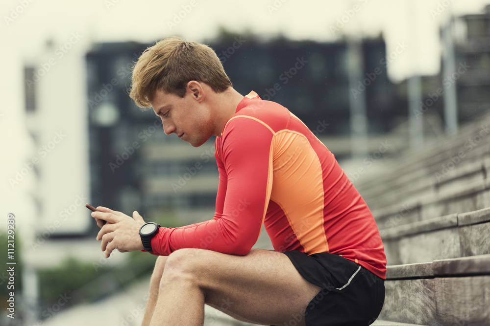 Fototapeta premium Jogger checking sport performance on his mobile phone 