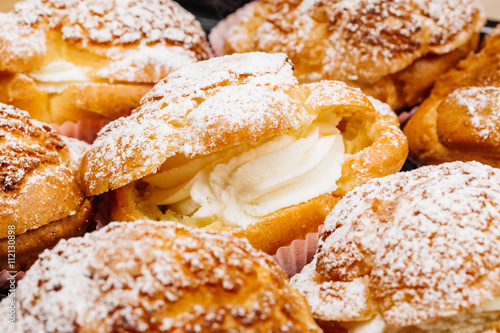 .Cream puffs filled with pastry cream and sprinkled with powdere