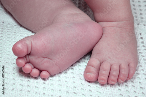 Newborn child cute feet on blanket