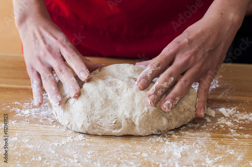 Homemade bread: female hands kneading dough. 