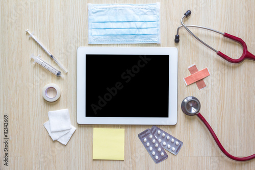 Top view of doctors desk with tablet and medical appliance