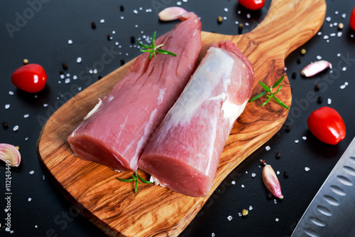 Foto Fresh Raw pork tenderloin on wooden board .ready to cook