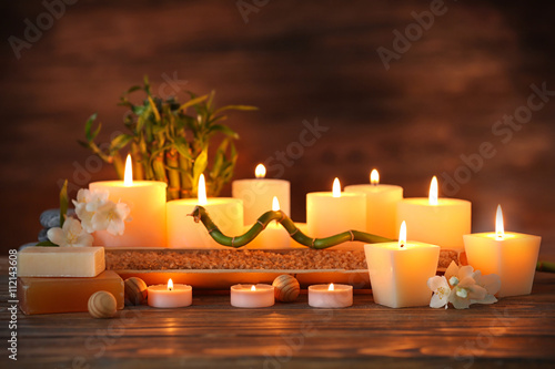 Spa composition with candles on brown background